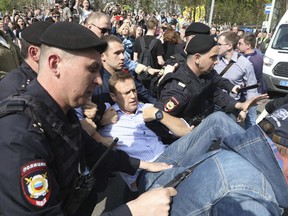 Russian police carrying a struggling opposition leader Alexei Navalny, center, at a demonstration against President Vladimir Putin in Pushkin Square in Moscow, Russia, Saturday, May 5, 2018. Thousands of demonstrators denouncing Putin's upcoming inauguration into a fourth term gathered Saturday in the capital's Pushkin Square. (AP Photo)
