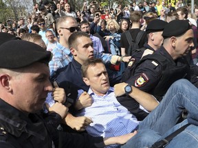 Russian police carrying struggling opposition leader Alexei Navalny, center, at a demonstration against President Vladimir Putin in Pushkin Square in Moscow, Russia, Saturday, May 5, 2018. Thousands of demonstrators denouncing Putin's upcoming inauguration into a fourth term gathered Saturday in the capital's Pushkin Square. (AP Photo)