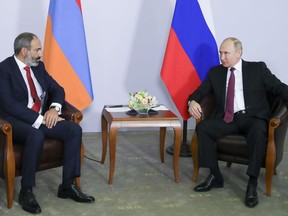 Armenian Prime Minister Nikol Pashinian, left, listens to Russian President Vladimir Putin during their meeting in the Black Sea resort of Sochi, Russia, Monday, May 14, 2018.