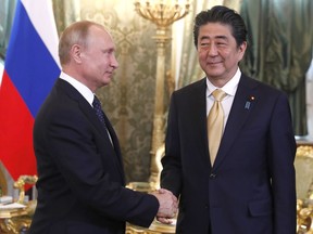 Japanese Prime Minister Shinzo Abe, right, shakes hands with Russian President Vladimir Putin during their meeting in Moscow, Russia, Saturday, May 26, 2018.