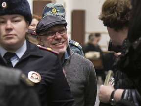 In this photo taken on Tuesday, Jan. 16, 2018, Alexei Malobrodsky, center, the former director of Moscow's Gogol Center, who was arrested in June of 2017, on charges of embezzling public funds allocated for a theater production is escorted to the court room in Moscow, Russia. A Russian theater manager accused of embezzlement has been released from prison following public outrage that he remained in detention after a health emergency.