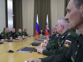 Russian President Vladimir Putin, background center, leads a meeting with the top military brass in the Bocharov Ruchei residence in the Black Sea resort of Sochi, Russia, Tuesday, May 15, 2018. Putin says the new weapons presented this year will ensure Russia's security for decades to come.