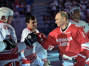 Russian President Vladimir Putin, right, is welcomed to take part in a match of the Night Hockey League teams in the Bolshoy Ice Arena in the Black Sea resort of Sochi, Russia, Thursday, May 10, 2018.