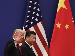 FILE - In this Nov. 9, 2017 file photo, U.S. President Donald Trump waves next to Chinese President Xi Jinping after attending a business event at the Great Hall of the People in Beijing. U.S. President Donald Trump's abrupt withdrawal from his planned summit with North Korea raises the stakes for China to show that it can steer the North toward easing tensions over its nuclear program. But despite a recent warming in ties, Beijing's influence over its neighbor may be overstated.