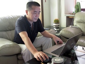 FILE - In this Sept. 18, 2012, file photo, veteran rights activist Huang Qi works on his laptop in his home in Chengdu in southwestern China's Sichuan province. Ten years after a massive earthquake devastated parts of China's Sichuan province, outspoken critic of the government's disaster response Huang Qi is languishing in prison awaiting trial amid deteriorating health. The longtime human rights advocate's predicament underscores the communist government's determination to silence all critics, including parents who lost their children when shoddily built schools collapsed in 2008.
