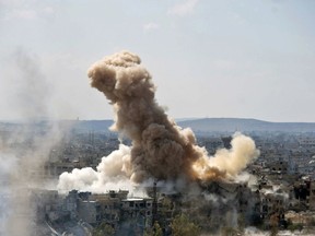 FILE - In this file photo released on Sunday, April 22, 2018 by the Syrian official news agency SANA, smoke rises after Syrian government airstrikes and shelling hit in Hajar al-Aswad neighborhood held by Islamic State militants, southern Damascus, Syria. Syria's military said Monday, May 21, 2018, that it has liberated the last neighborhoods in southern Damascus held by the Islamic State and has declared the Syrian capital and its surroundings "completely safe" and free of any militant presence. (SANA via AP, File)