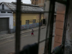 In this March 30, 2018 photo, a woman walks past an abandoned building occupied by squatters in downtown Johannesburg, South Africa. The mayor wants the city's squatters cleared out to make way for an urban revival, with proposals to expropriate buildings and turn them over to private developers.