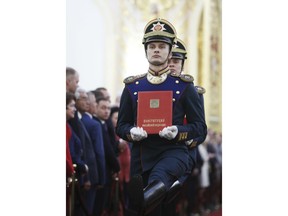 Honour guard soldiers carry the Constitution prior to Vladimir Putin's inauguration ceremony as new Russia's president in the Grand Kremlin Palace in Moscow, Russia, Monday, May 7, 2018.  Putin won the six-year term in March elections where he tallied 77 percent of the vote.