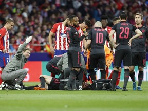 Arsenal's Laurent Koscielny receives a medical help during the Europa League semifinal, second leg soccer match between Atletico Madrid and Arsenal at the Metropolitano stadium in Madrid, Spain, Thursday, May 3, 2018.