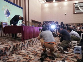 Nihon University's American football player Taisuke Miyagawa, left, bows at a news conference Tuesday, May 22, 2018, in Tokyo. The Japanese college football player has apologized for intentionally injuring the quarterback of an opposing team, an incident that has riveted Japan for several weeks.  In a news conference broadcast live across Japan, Miyagawa bowed deeply and said his coach had told him to do it - but he said he should have been stronger and refused the coaching order.