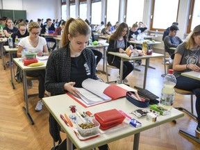 FILE - In this April 18, 2018 file photo students take a look at an exam test at the Graf-Zeppelin-Gymnasium in Friedrichshafen, Germany. High school students in Germany have been complaining in an online petition about their final exam in English saying the test was much harder than in previous years. As of Sunday May 6, 2018, students in the southwestern state of Baden-Wuerttemberg had gathered almost 36,000 signatures _ even though only 33,500 participated in last month's statewide exam. The final high school exams in Germany - called Abitur - are a rite of passage that all students who want to enter university have to pass.