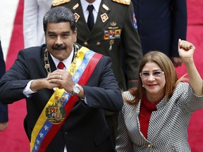 Venezuela's President Nicolas Maduro, left, and first Lady Cilia Flores gesture to the media as they arrive for a session with the Constituent Assembly in Caracas, Venezuela, Thursday, May 24, 2018. Maduro will present the assembly with his credentials as Venezuela's re-elected leader, following the May 20 presidential election.