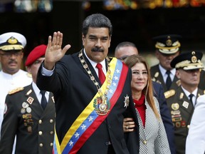 Venezuelan President Nicolas Maduro and first lady Cilia Flores greet the media as they arrive at a military parade in Caracas, on May 24, 2018.