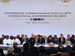 French President Emmanuel Macron, center, holds an International Conference on Libya is held at the Elysee Palace with representatives of twenty countries, including Libya's neighbors, regional and Western powers and international organizations and the French President Emmanuel Macron at the Elysee Palace in Paris, France, Tuesday May 29, 2018. Libya's rival leaders meet in Paris to agree on a political roadmap including elections in an effort to bring order out of Libya's chaos, which is feeding Islamic militants, traffics of all kind and instability in the region.