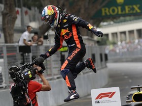 Red Bull driver Daniel Ricciardo of Australia jumps from his car to celebrate after winning the Formula One race, at the Monaco racetrack, in Monaco, Sunday, May 27, 2018.