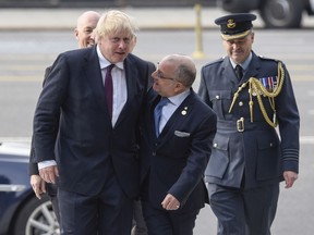British Foreign Secretary Boris Johnson, left, and Argentine Foreign Secretary Jorge Faurie, center, arrive to the Monument of the Fallen Soldiers in honor of soldiers who died in the Falklands War in Buenos Aires, Argentina, Sunday, May 20, 2018.