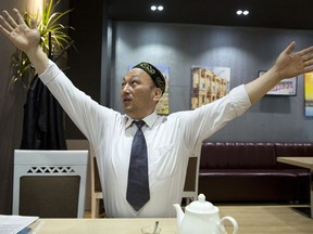 In this March 29, 2018, photo, Omir Bekali demonstrates how he was strung up by his arms in Chinese detention before being sent to an internment camp during an interview in Almaty, Kazakhstan. Since 2016, Chinese authorities in the heavily Muslim region of Xinjiang have ensnared tens, possibly hundreds of thousands of Muslim Chinese, and even foreign citizens, in mass internment camps. The program aims to rewire detainees' thinking and reshape their identities. Chinese officials say ideological changes are needed to fight Islamic extremism.