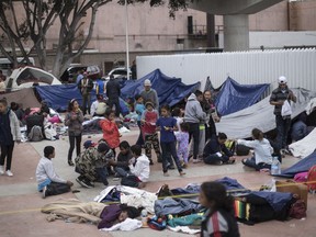 Migrants wait for access to request asylum in the US, at the El Chaparral port of Entry in Tijuana, Mexico, Monday, April 30, 2018. bout 200 people in a caravan of Central American asylum seekers waited on the Mexican border with San Diego for a second straight day on Monday to turn themselves in to U.S. border inspectors, who said the nation's busiest crossing facility did not have enough space to accommodate them.