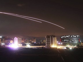 This photo provided early Thursday, May 10, 2018, by the government-controlled Syrian Central Military Media, shows missiles rise into the sky as Israeli missiles hit air defense position and other military bases, in Damascus, Syria. The Israeli military on Thursday said it attacked "dozens" of Iranian targets in neighboring Syria in response to an Iranian rocket barrage on Israeli positions in the Golan Heights, in the most serious military confrontation between the two bitter enemies to date.