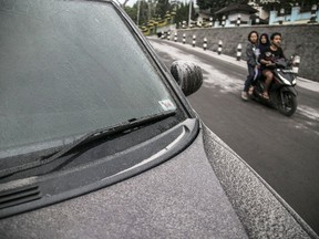 A car is covered by ash from the eruption of Mount Merapi in Yogyakarta, Indonesia, Monday, May 21, 2018. Indonesia's most volatile volcano spewed smoke and ash early Monday in the latest of several eruptions in less than two weeks.