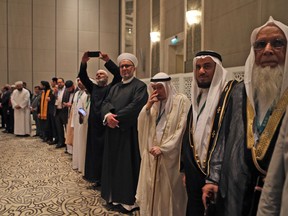 High ranking Muslim clerics stand to greet the United Arab Emirates Minister of State for Tolerance, during the opening of the International Muslims Communities Congress, in Abu Dhabi, UAE, Tuesday, May 8, 2018. The UAE hosted a forum for the first time that gathers Islamic community leaders from countries around the world where Muslims are minorities to network and discuss challenges around issues of Islamophobia, integration and extremism.