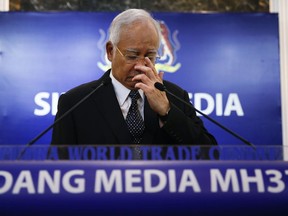 FILE - In this Aug. 6, 2015, file photo, Malaysian Prime Minister Najib Razak, center, pauses before speaking at a news conference announcing the findings for the ill fated flight Malaysia Airlines Flight 370 in Kuala Lumpur, Malaysia.
