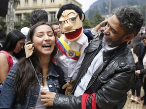 FILE - In this May 15, 2018 file photo, a supporter of presidential candidate Gustavo Petro manipulates a puppet depicting Petro wearing a presidential sash, at a campaign rally in Bogota, Colombia. The 58-year-old former guerrilla and ex-Bogota mayor is promising to overhaul Colombia's economic model, galvanizing the youth vote to place second in most polls.