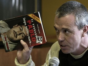 FILE - In this June 27, 2006 file photo, Jhon Jairo Velasquez, a former hit man for Pablo Escobar, gives his testimony while holding a book titled "The True Pablo, Blood, Treason, and Death," during the trial against Alberto Santofimio Botero in Bogota, Colombia. Colombian police re-arrested the former hit man, known by his nickname Popeye, on Friday, May 25, 2018, as part of an investigation into extortion.