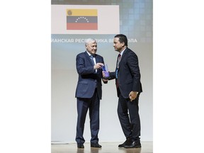 In this March 28, 2018 photo provided by Russia's Association of Cryptocurrency and Blockchain (RACIB), Russian lawmaker Anatoliy Aksakov, left, presents Venezuelan Ambassador to Russia Carlos Faria with the Satoshi Nakamoto special award for Venezuela's role "challenging the de-facto powers of the international financial system" at the Blockchain Economy awards ceremony in Moscow, Russia. Russia is playing a role in the creation of Venezuela's state-backed cryptocurrency that much of the digital world has shunned but that Venezuelan President Nicolas Maduro hopes will allow Venezuela to circumvent U.S. financial sanctions imposed last year.
