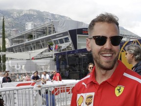 Ferrari driver Sebastian Vettel of Germany smiles as he walks in the paddock prior to a news conference at the Monaco racetrack, in Monaco, Wednesday, May 23, 2018. The Formula one race will be held on Sunday.