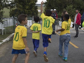 Boys, wearing Brazilian national team Neymar jerseys, celebrate because they were allowed entry at the Granja Comary training center to watch the national soccer team training session, in Teresopolis, Brazil, Friday, May 25, 2018. Neymar, the world's highest paid soccer player, is nearly recovered from a foot operation and has joined 16 of his teammates in Teresopolis, looking ahead to competing in Russia at the World Cup in July.