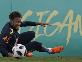 Brazil's Neymar smiles after taking a spill on the pitch during a national soccer team practice session ahead the World Cup in Russia, at the Granja Comary training center In Teresopolis, Brazil, Friday, May 25, 2018. Neymar, the world's highest paid soccer player, is nearly recovered from a foot operation and has joined 16 of his teammates in Teresopolis, looking ahead to competing in Russia at the World Cup in July.