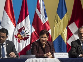 In this Nov 24, 2016 photo, Guatemala's Attorney General Thelma, center, sits with Ivan Velasquez, commissioner of the U.N. International Commission Against Impunity (CICIG), right, and Guatemalan President Jimmy Morales during the annual CICIG report in Guatemala City. Velasquez told the AP that trust did not come immediately between him and Aldana, but over time they developed a close working relationship where they were able to reconcile differences and reach consensus. What cemented his confidence was when she didn't shy away from going after then-President Otto Perez Molina.