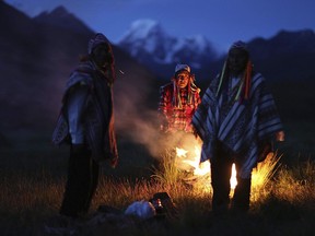 In this April 4, 2018 photo, Andean farmers take part in a ceremony honoring Mother Earth and Father Snowy Mountain, in Pitumarca, Peru. The surge in tourists comes with a responsibility to be good stewards of the environment and their new guests says Pampachiri community leader Gabino Huaman who admits he is not sure they are ready to fully handle it. AP Photo/Martin Mejia)
