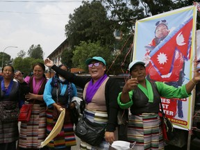 Friends and family dance while they wait for Nepalese veteran Sherpa guide, Kami Rita, 48, in Kathmandu, Nepal, Sunday, May 20, 2018. Rita, scaled Mount Everest on Wednesday morning May 16 for the 22nd time, setting the record for most climbs of the world's highest mountain, officials said.
