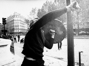 FILE - In this May 6 1968 file photo, a demonstrator throws rocks at police during a protest in Paris. The 50th anniversary of France's biggest revolt since World War II is sparking more enthusiasm in arts and intellectual circles, though, with a series of exhibitions staged in Paris.