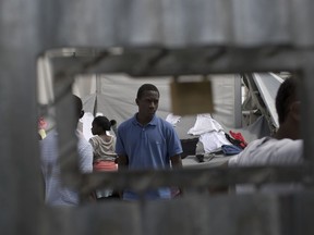 In this Friday, May 4, 2018 photo, newly arrived migrants and refugees wait to be registered by authorities in Moria Camp, on Lesbos, Greece. The eastern Aegean island is facing a fourth summer of immigration crisis as the country struggles to emerge from recession.