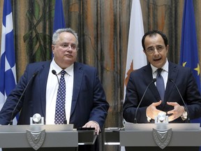 Cyprus Foreign Minister Nikos Christodoulides, right, and his Greek counterpart Nikos Kotzias talk to the media during a press conference after their meeting at the foreign ministry in capital Nicosia, Cyprus, Monday, May 7, 2018.  Kotzias says the European Union should reject new Syrian real estate legislation that he says would hinder the return of Syrian refugees to their homes and property.