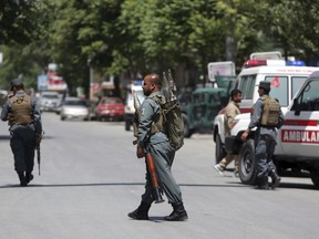 Afghan security personnel inspect the area of a suicide attack in the center of Kabul, Afghanistan, Wednesday, May 9, 2018. Three suicide bombers struck two police stations in Afghanistan's capital on Wednesday, wounding at least six people, officials said.