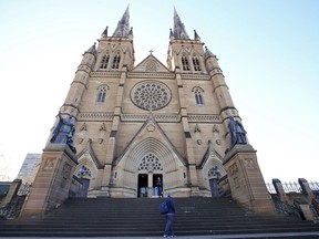 People visit St. Mary's Cathedral in Sydney, Thursday, May 31, 2018. Australia's Catholic bishops and leaders of its religious orders have committed to signing on to the 3.8 billion Australian dollar ($2.9 billion) national plan that will ensure compensation will be paid to people who were sexually abused as children by church figures and puts pressure on other institutions to follow suit.