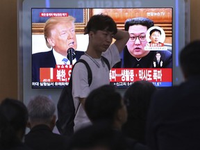 People watch a TV screen showing file footage of U.S. President Donald Trump, left, and North Korean leader Kim Jong Un during a news program at the Seoul Railway Station in Seoul, South Korea, Thursday, May 24, 2018. North Korea carried out what it said is the demolition of its nuclear test site Thursday, setting off a series of explosions over several hours in the presence of foreign journalists.The signs read: " North Korea demolishes nuclear test site ."