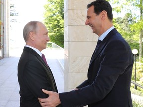 Russian President Vladimir Putin, left, reacts with Syrian President Bashar al-Assad during their meeting in the Black Sea resort of Sochi, Russia, Thursday, May 17, 2018. A transcript of Thursday's meeting released by the Kremlin quoted Assad as saying that Syria is making progress in fighting "terrorism," which "opens the door to the political process."