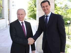 Russian President Vladimir Putin, left, shakes hands with Syrian President Bashar al-Assad during their meeting in the Black Sea resort of Sochi, Russia, Thursday, May 17, 2018.  A transcript of Thursday's meeting released by the Kremlin quoted Assad as saying that Syria is making progress in fighting "terrorism," which "opens the door to the political process."