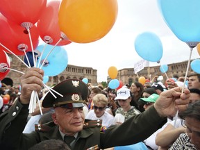 An Armenian army officer hands out balloons during a rally in Republic Square in Yerevan, Armenia, Tuesday, May 8, 2018. The Armenian opposition leader Nikol Pashinian, who is nearly certain to become the country's prime minister says he will not seek political revenge in the wake of the past month of tensions. Pashinian, who led weeks of protests that attracted tens of thousands of people and forced Serzh Sargsyan to resign as premier, is expected to be chosen prime minister by parliament on Tuesday.