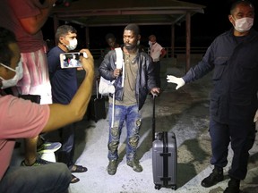 In this photo released by Maranhao state, an unidentified African migrant arrives after he was rescued by fishermen, at the pier of Sao Jose de Ribamar, Brazil, Sunday, May 20, 2018. Authorities say about two dozen African migrants have come ashore in northeastern Brazil after being rescued at sea by fishermen.