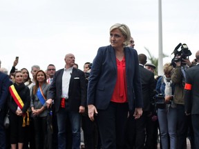 French far right leader Marine Le Pen stands after laying a wreath in front of the statue of Joan of Arc, in Cannes, south of France, Tuesday, May 1, 2018. Le Pen gathers other anti-immigration populist leaders from around Europe for a May Day gathering aimed at energizing their campaigns for European Parliament elections next year.