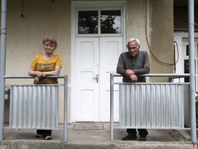 In this photo taken on Sunday, May 6, 2018, Vova PashinIan, right, father of the Armenian protest leader Nikol Pashinian, and Erdzhanuhi, his stepmother, stand outside their house, in Idjevan town, northern Armenia. Hope has bloomed in the hometown of Armenia's newly-named prime minister, for people see him as a man who was able to articulate their anger and will now focus on their needs. Nikol Pashinian, who spearheaded weeks of anti-government protests, was named the country's new leader on May 8. Like the rest of the country, his hometown Idjevan, a city of 20,000 that sits on a key highway linking Armenia with Georgia, has been plagued by unemployment and grinding poverty after a plant processing bentonite clay and other factories closed years ago. His father recalled that his son once told him: "If I don't fight, how will our people live? In poverty? Unemployment?"