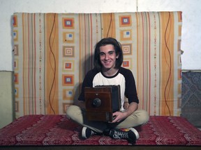 In this Friday, May 4, 2018 photo, Toros Khachaturian, 20, director of photography poses with an old camera in Yerevan.  Many young hopefuls believe that major political changes in this poverty-ridden former Soviet republic, could bring back many Armenians who fled the country to seek their fortunes abroad.
