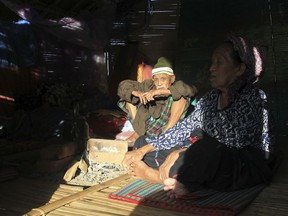 In this May 6, 2018, photo, ethnic Kachin Hkaraw Yaw, left, sits along with his wife Nlam Numrang Doi at their hut in compound of Trinity Baptist Church refugee camp in Myitkyina, Kachin State, northern Myanmar. Myanmar's army, notorious for perpetrating violence that drove 700,000 Muslim ethnic Rohingyas to flee to neighboring Bangladesh, now stands accused of fostering a similar humanitarian crisis in the country's north, where it battles guerrillas of the Christian Kachin minority.