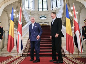 Britain's Prince Charles, left, takes his position for a handshake with Romanian President Klaus Iohannis at the Cotroceni Presidential Palace, in Bucharest, Romania, Wednesday, May 30, 2018. Britain's Prince Charles has arrived in Bucharest.